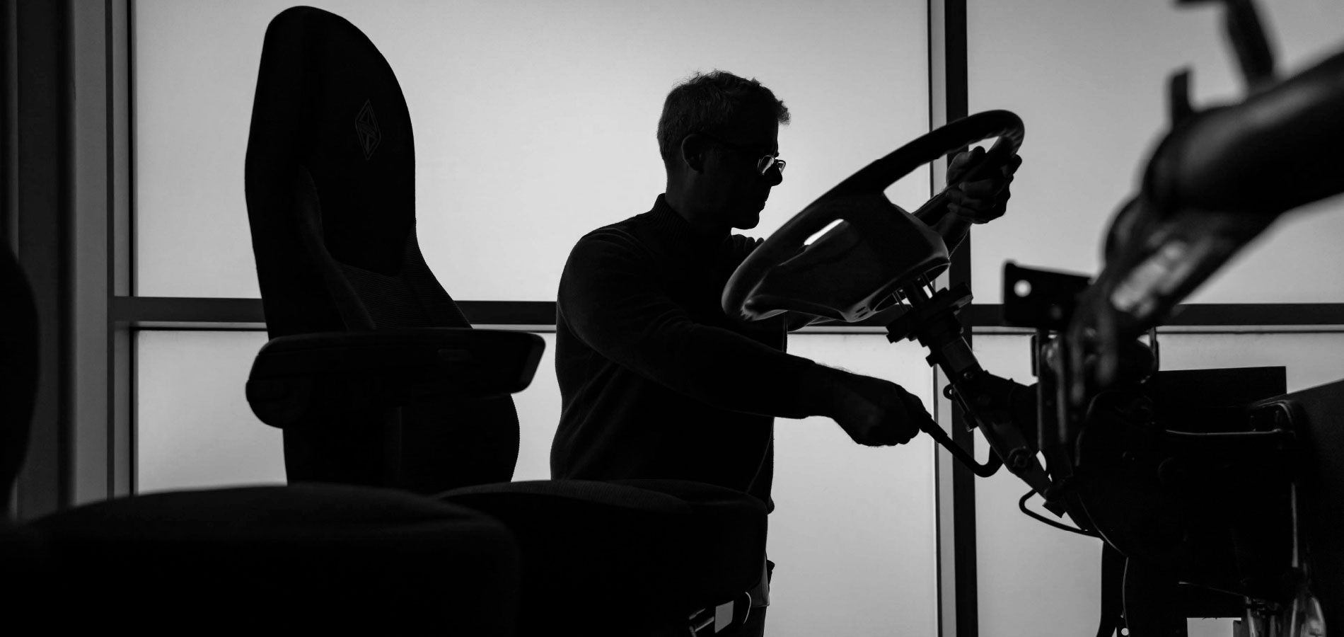 Silhouette of a man working on truck frame