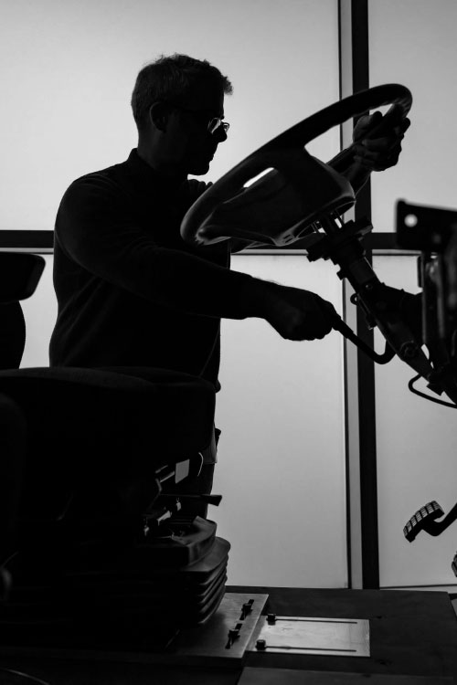 Silhouette of a man working on truck frame